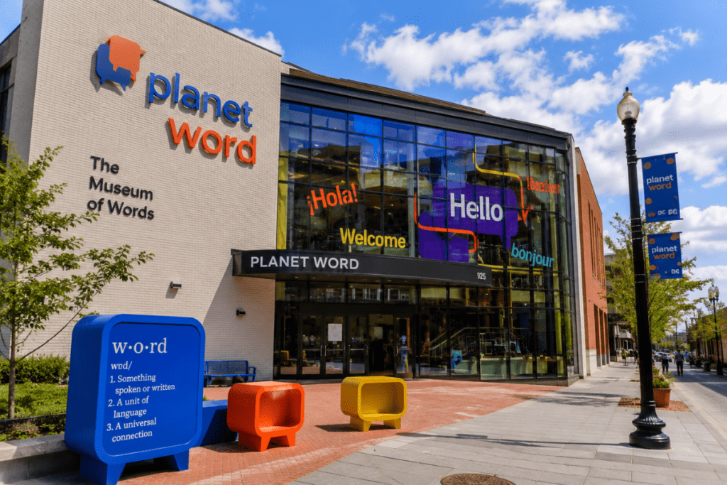 Planet Word museum in Washington DC with colorful word displays, glass windows, and a bright city street view.